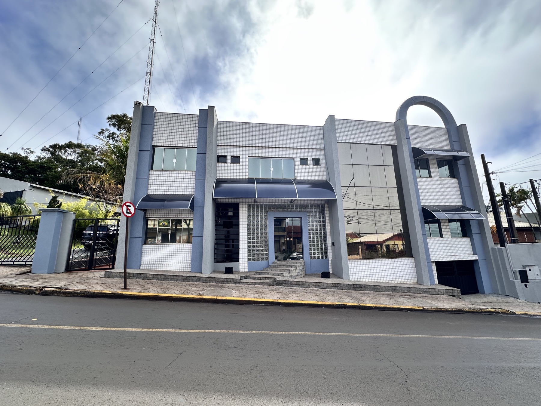 Fachada frontal do prédio da Rádio Graúna FM em Cornélio Procópio, com torre de transmissão ao fundo